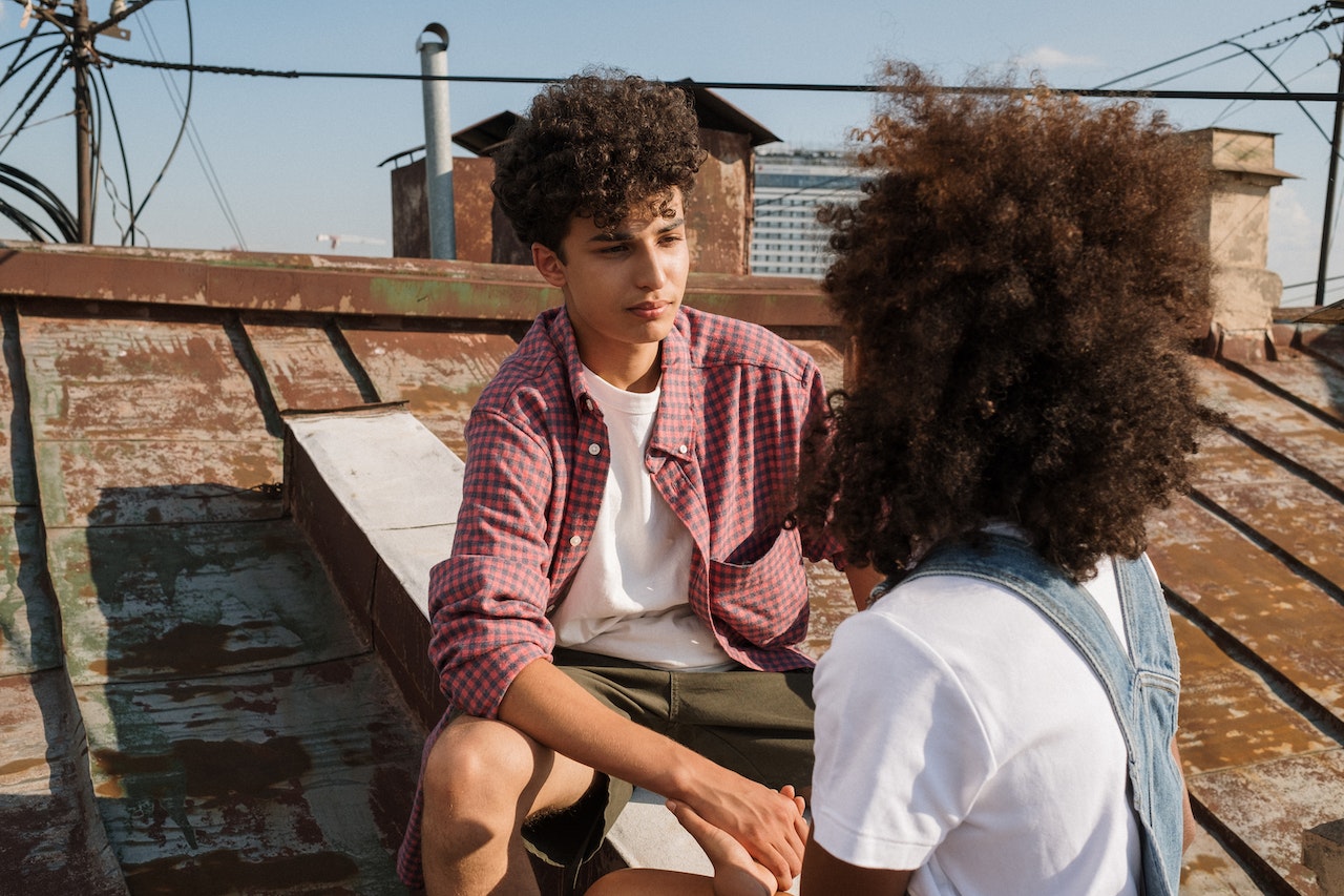 couple d'adolescents assis sur un toit