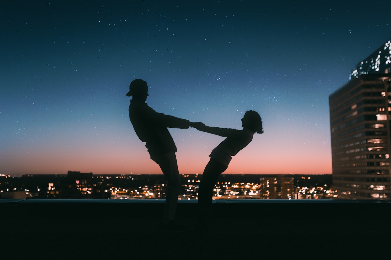 couple se tenant la main au coucher du soleil 